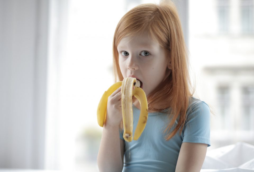 Girl Eating Banana which is rich source of potassium